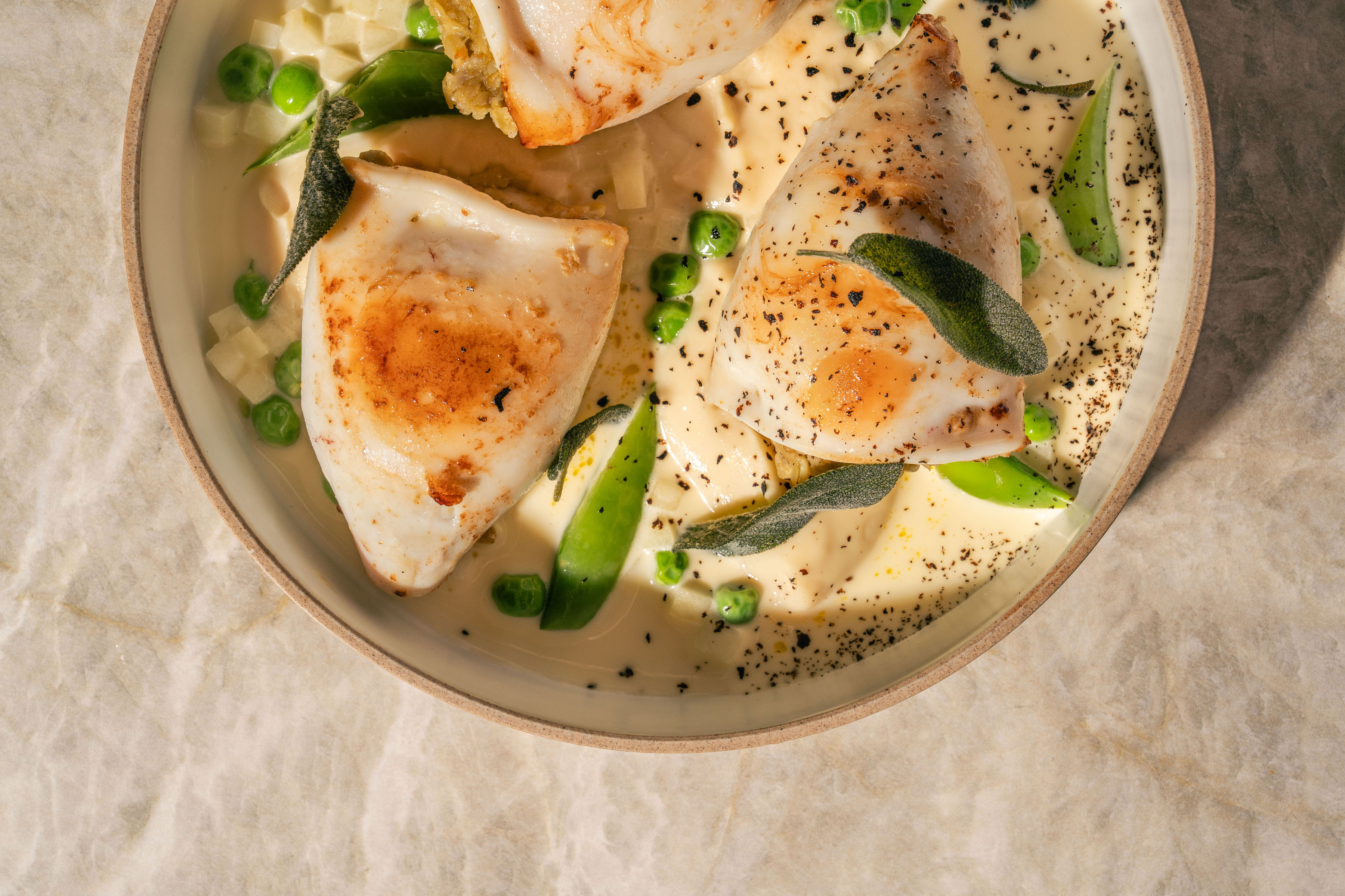 Stuffed calamari with peas and sage in a creamy sauce